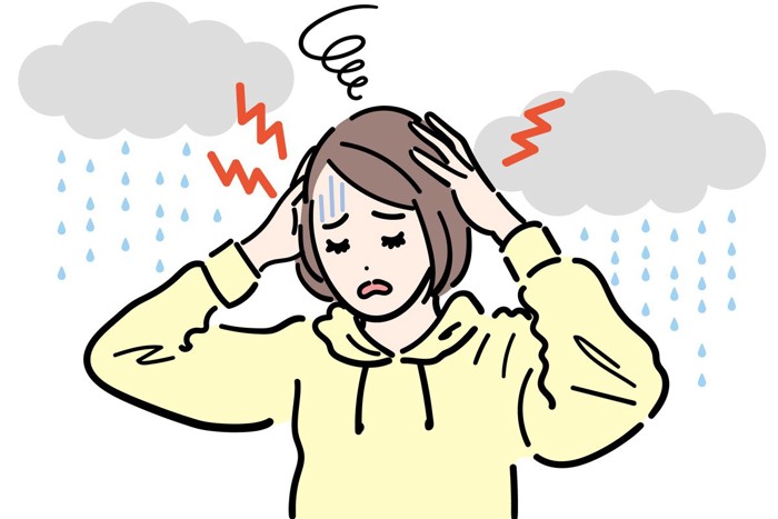 気象病による頭痛で悩んでいる女性