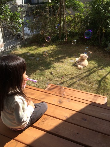 子どもと犬が庭でくつろぐ写真