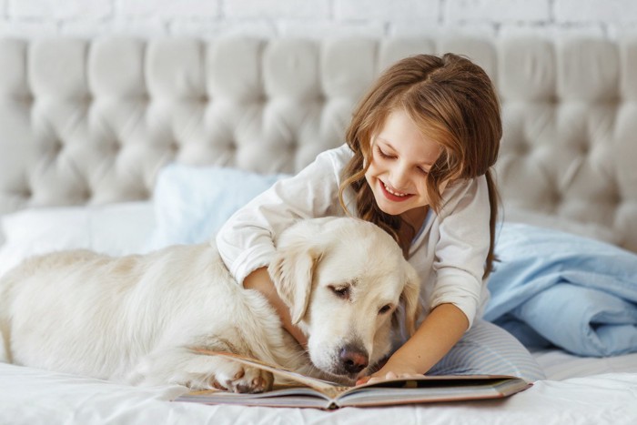犬に本を読んであげる女の子