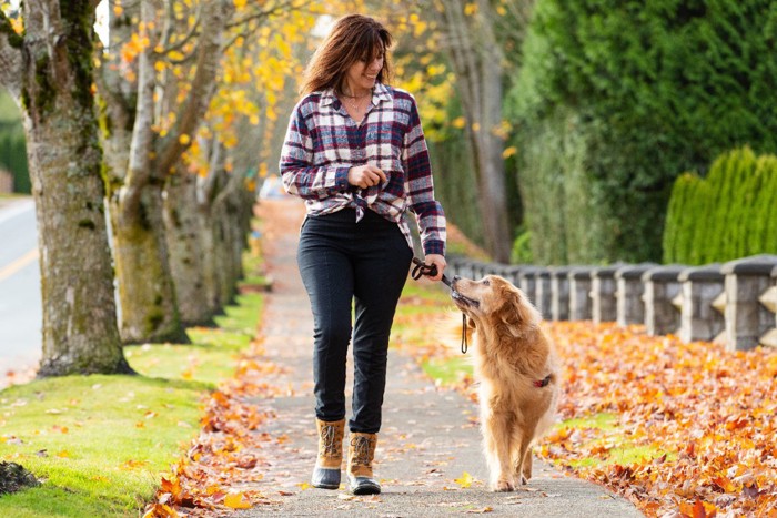 アイコンタクトを取りながら散歩を楽しむ女性と犬