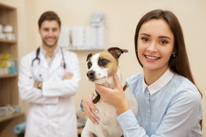 病院で相談する飼い主と犬